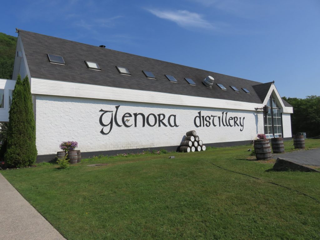 A white building with Glenora Distillery written on it in a Celtic font