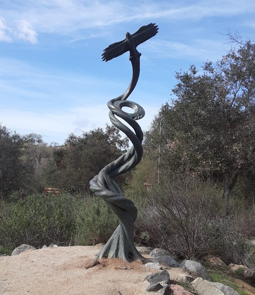 A statue with a bird on top of a twisted column